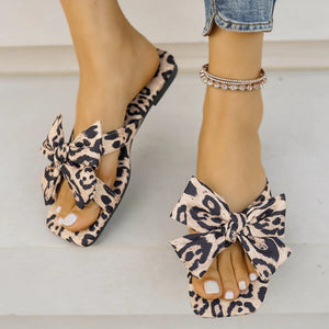 Leopard print bow flat sandals with square toe and ankle bracelet.