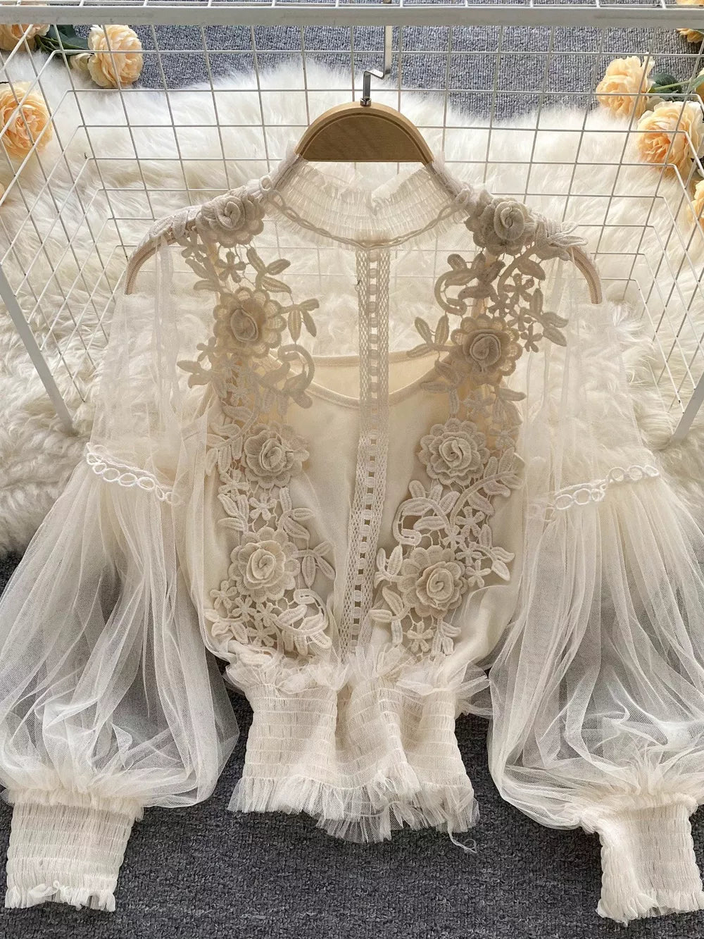 Creamy-white lace blouse with floral embroidery and sheer puff sleeves.