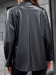Black faux leather shacket with button-down collar and long sleeves.