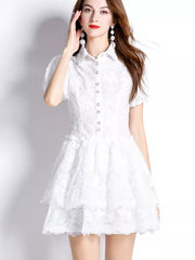 White lace mini dress with puff sleeves, buttoned front, and tiered ruffled skirt.
