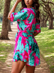 Tropical print wrap romper with tie waist in turquoise and pink floral pattern.