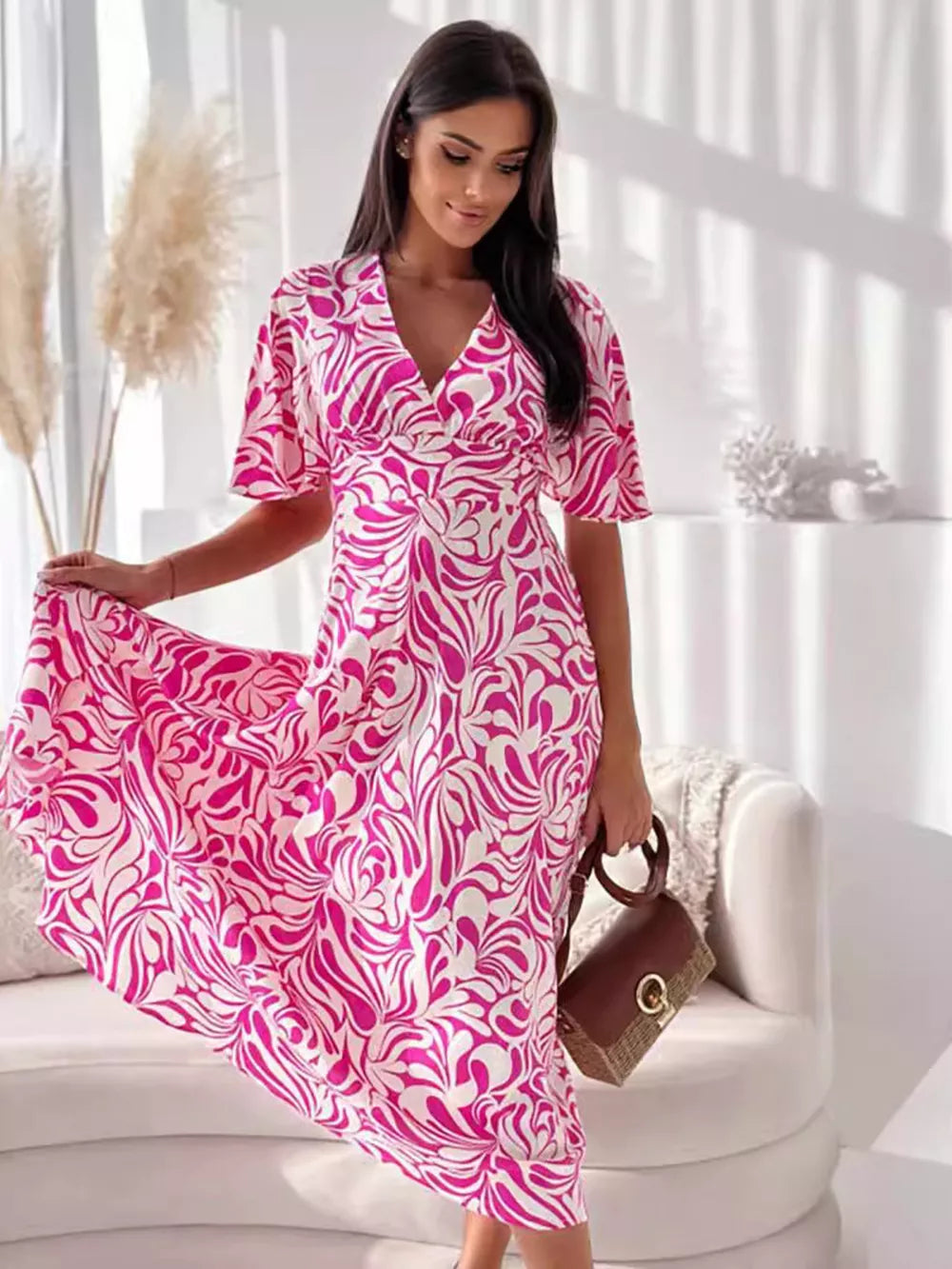 Vibrant hot pink and white abstract pattern midi dress with flutter sleeves and a v-neck.