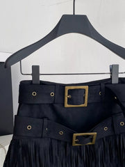 Black belted mini skirt with fringe hem and antique brass buckle detail.