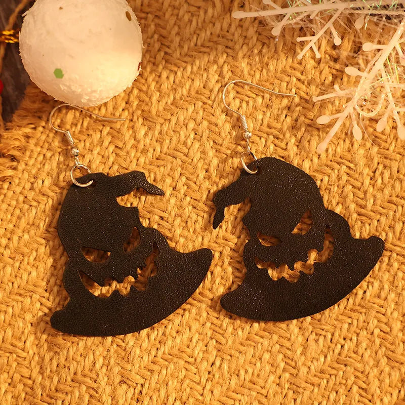 Black leather witch hat earrings with carved jack-o'-lantern faces.