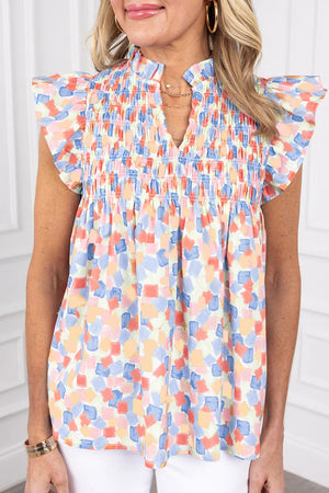 Smocked bodice blouse with brushstroke print in pastel blue, teal, and sherbet colors, featuring flutter sleeves.