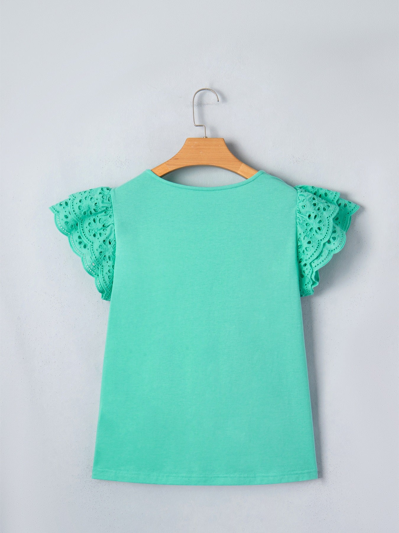 Eyelet lace ruffled cap sleeve top in mint green with cutout detail on sleeves.