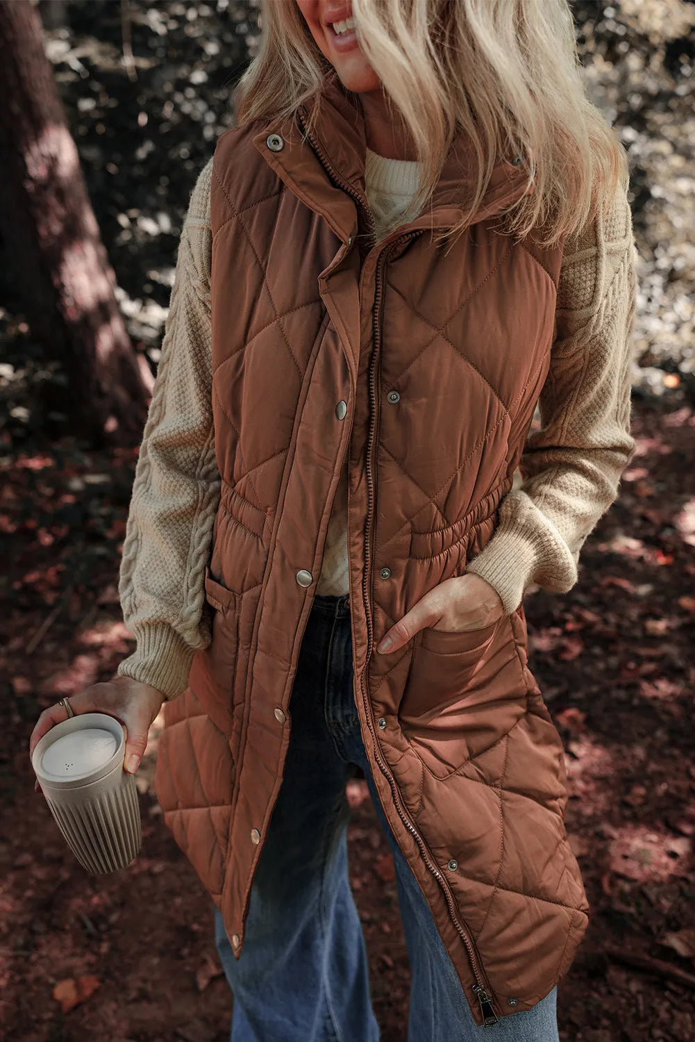 Brown diamond quilted longline vest with cinched waist detail and snap buttons.