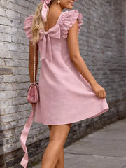 Pink a-line dress with ruffled cap sleeves and a large back bow detail.