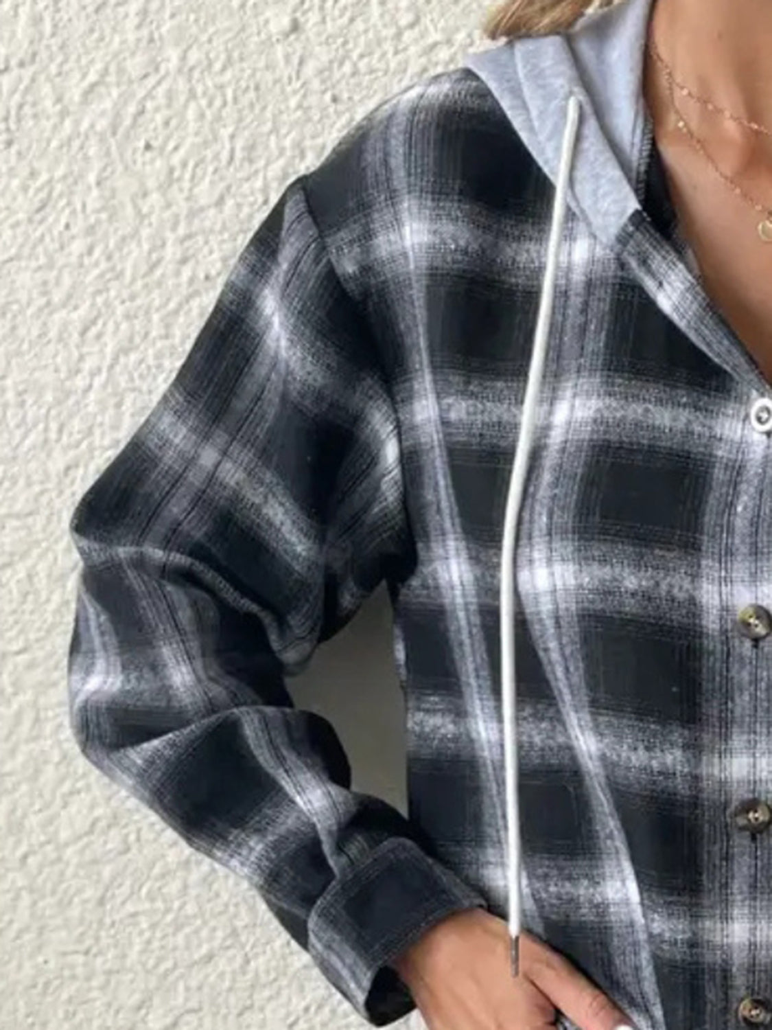 Black plaid shirt jacket with contrast grey hood and white drawstring.