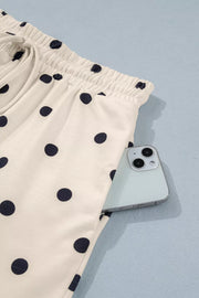 Cream polka dot bikini bottoms with drawstring waist and pocket detail.