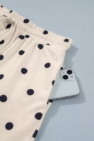 Cream polka dot bikini bottoms with drawstring waist and pocket detail.