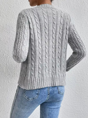 Gray cable-knit button-front cardigan with textured sleeves and ribbed hem.