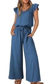 Dusty blue textured drawstring palazzo jumpsuit with ruffle sleeves and wide legs.