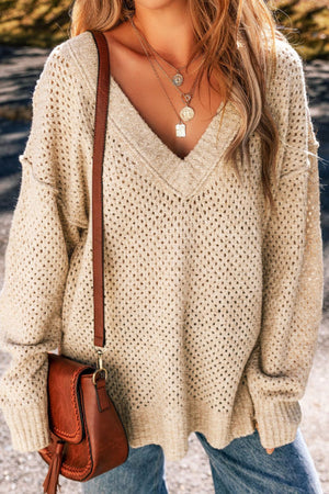 Beige open-knit slouchy V-neck sweater with a relaxed fit and long sleeves.