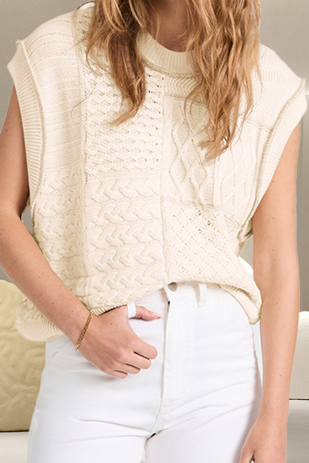 Ivory knit patchwork vest with cable and diamond patterns, mock neck, sleeveless.