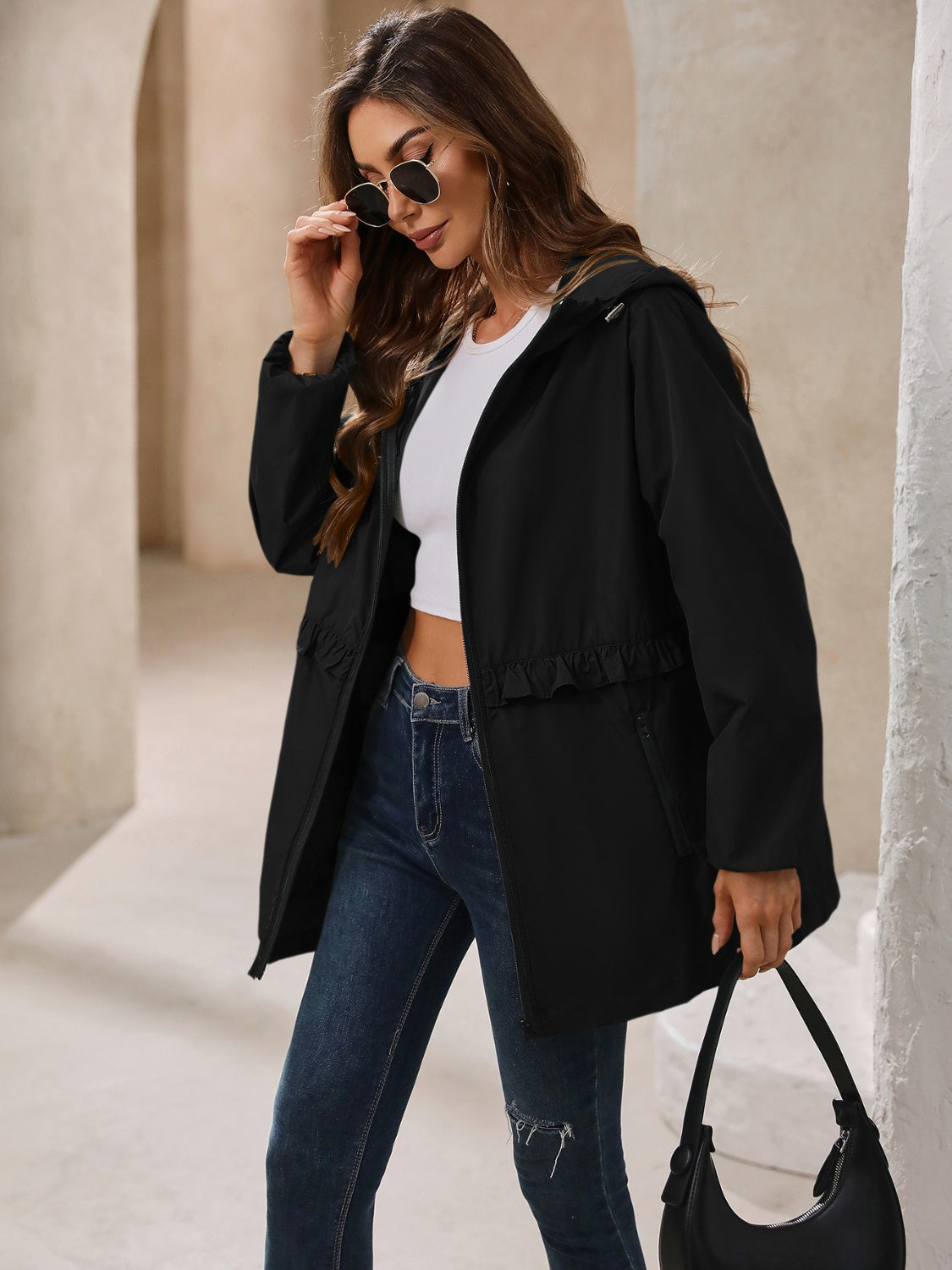 Black hooded windbreaker jacket with ruffled waistline detail and zip pockets