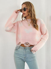 Blush pink knit cropped sweater with distressed details and white butterfly print.