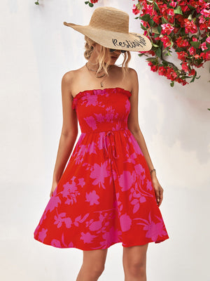 Smocked bandeau mini dress in red with pink floral print, drawstring waist, and ruffled neckline.