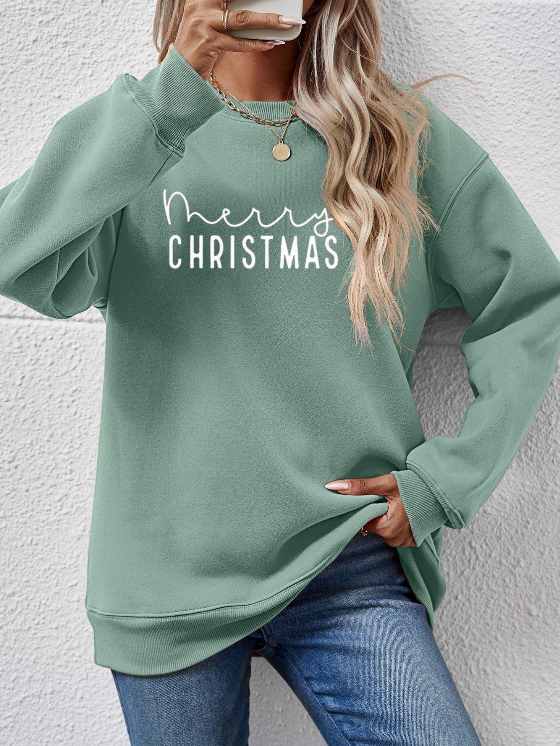 Sage green crewneck sweatshirt with white Merry Christmas graphic, casual relaxed fit.