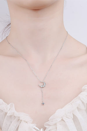 Silver celestial pendant necklace with crescent moon and star charms.