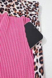 Pink ribbed pajama pants with leopard print waistband and trim.