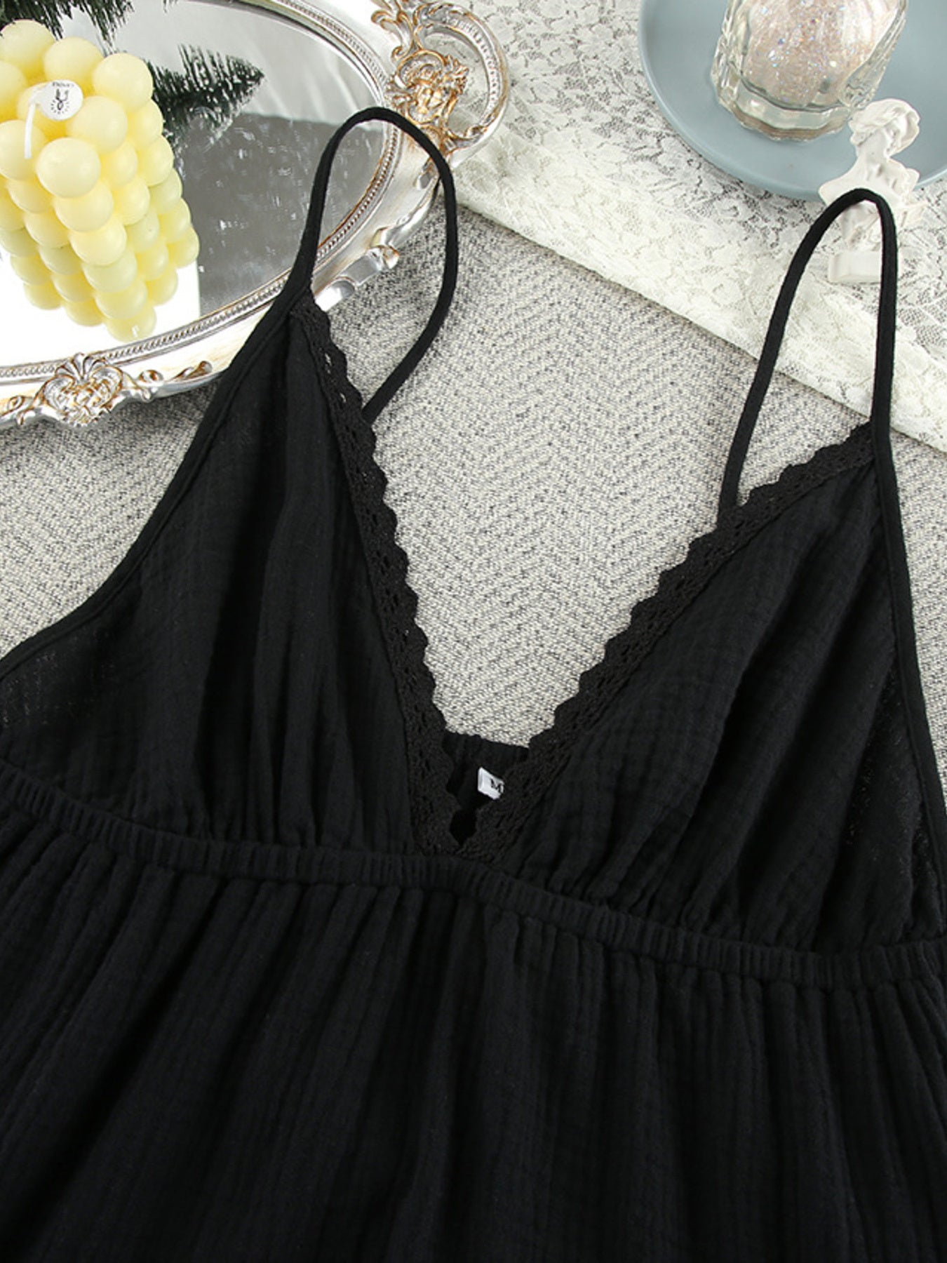 Black cotton tiered mini dress with lace trim V-neck and adjustable spaghetti straps.