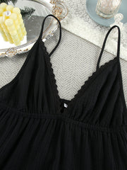 Black cotton tiered mini dress with lace trim V-neck and adjustable spaghetti straps.