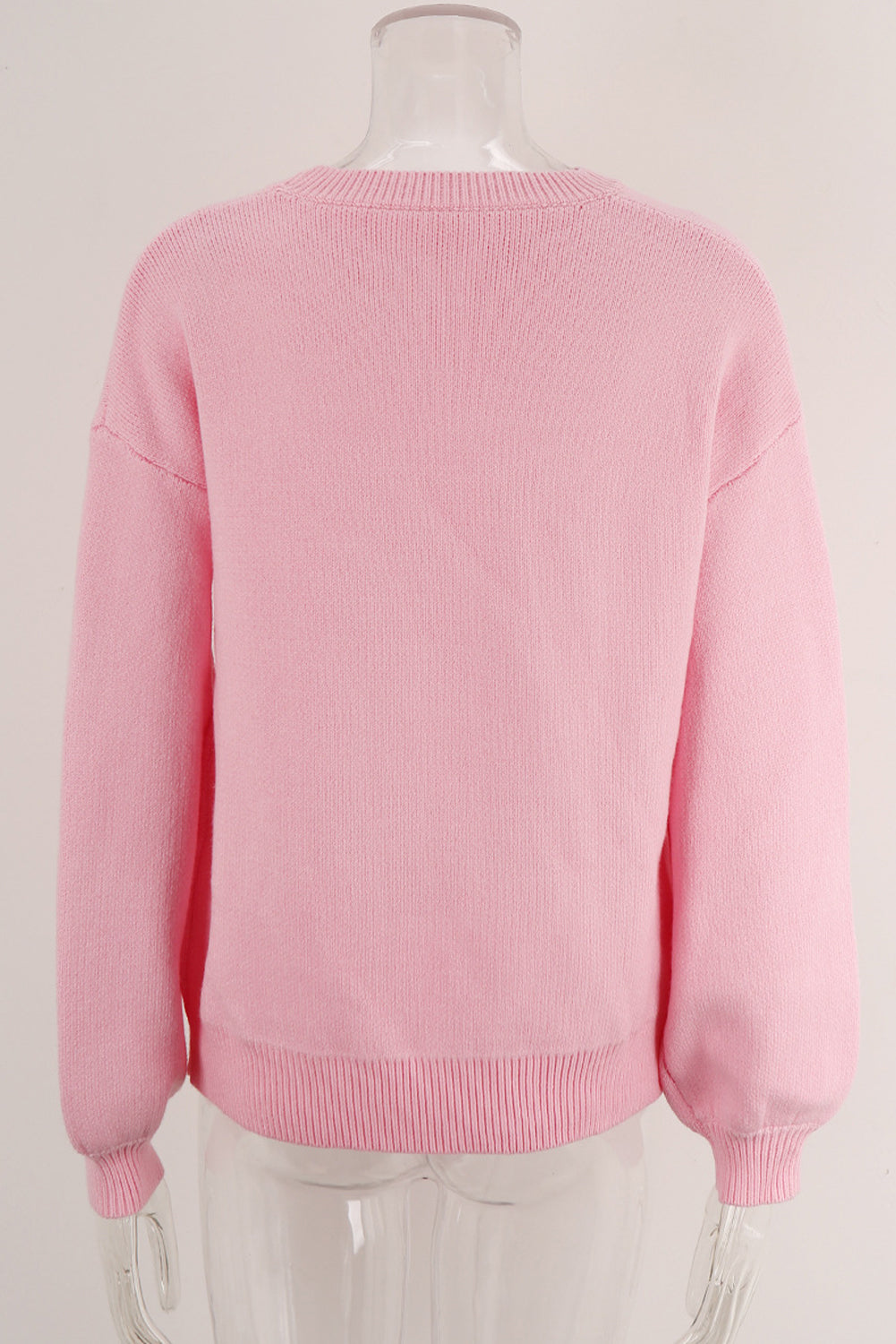 Blush pink acrylic knit sweater with graphic bow intarsia detail and crew neck.