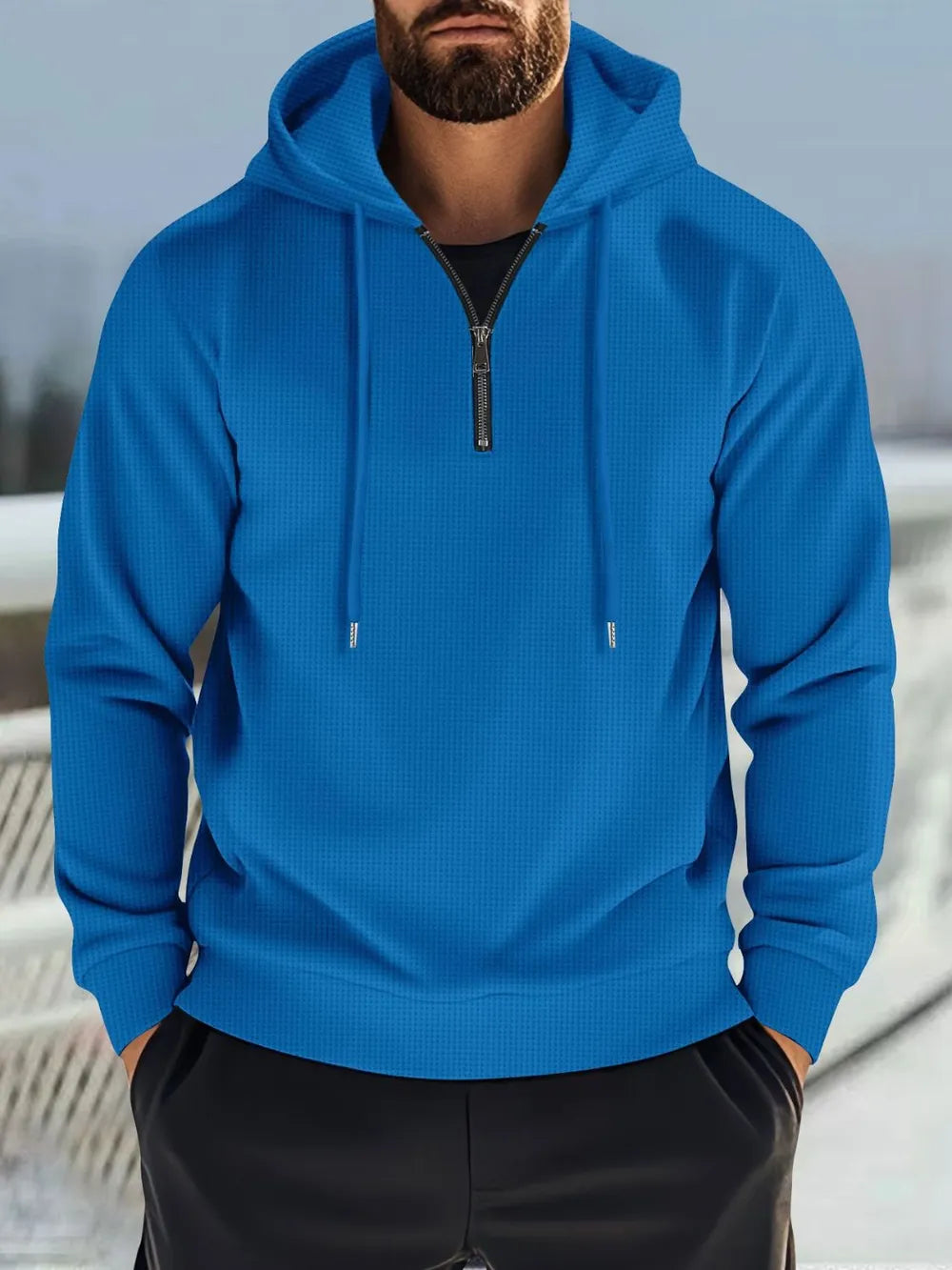 Blue waffle-knit quarter-zip hooded pullover with drawstring hood and black t-shirt.
