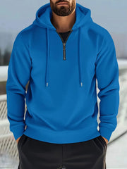 Blue waffle-knit quarter-zip hooded pullover with drawstring hood and black t-shirt.