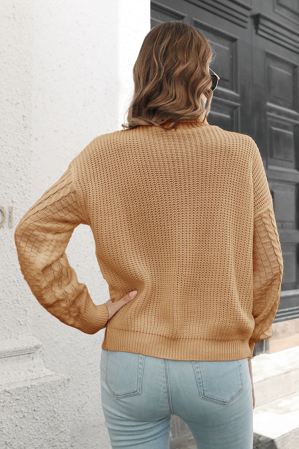 Camel cable knit turtleneck sweater with chevron detail on sleeves.