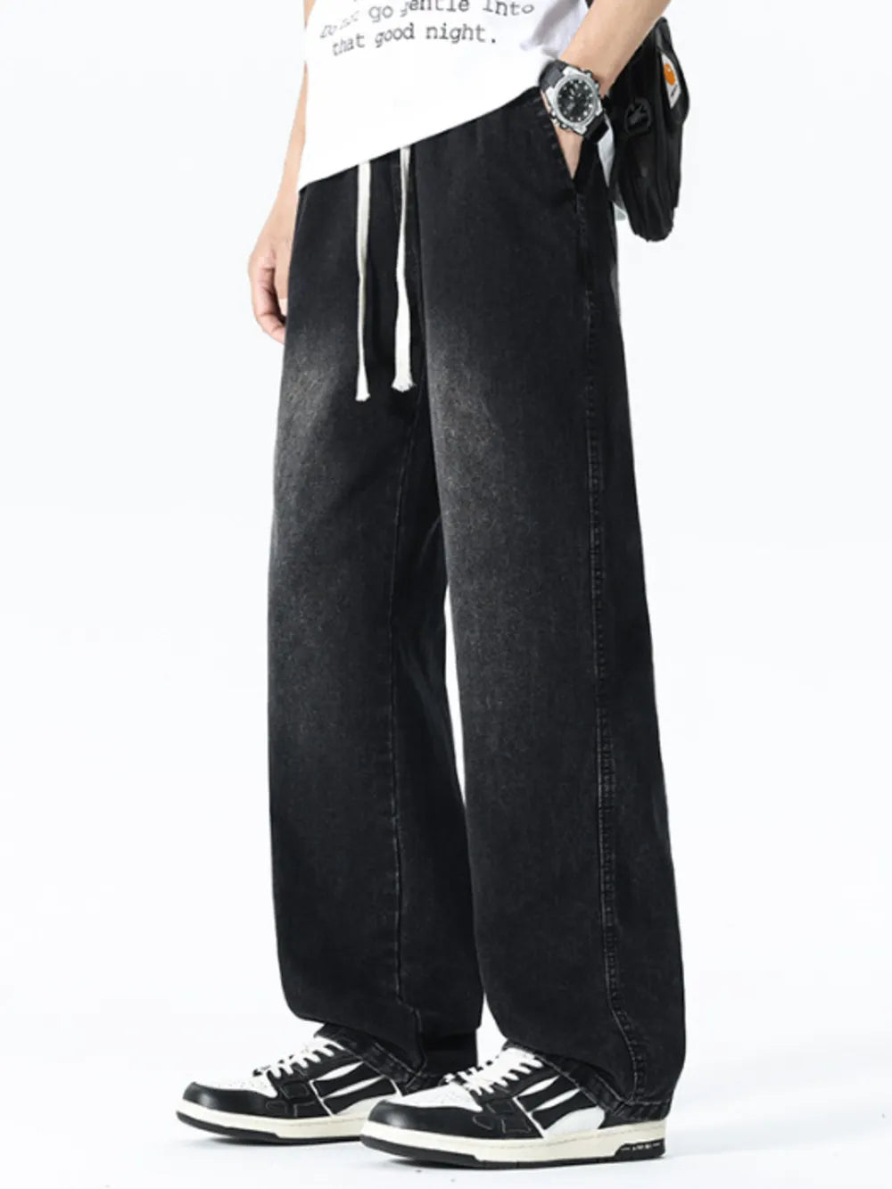 Relaxed wide leg black denim jeans with drawstring waist and pockets.