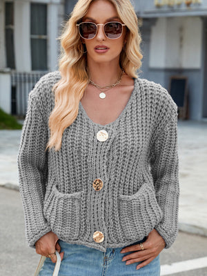Gray chunky knit cardigan with gold buttons and front pockets.