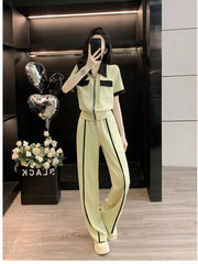 Chic zip-up top with black trim and wide-leg pants set in light green.
