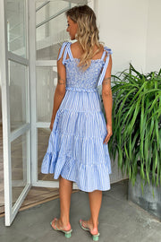Pastel blue striped smocked bodice tiered midi dress with tie straps.