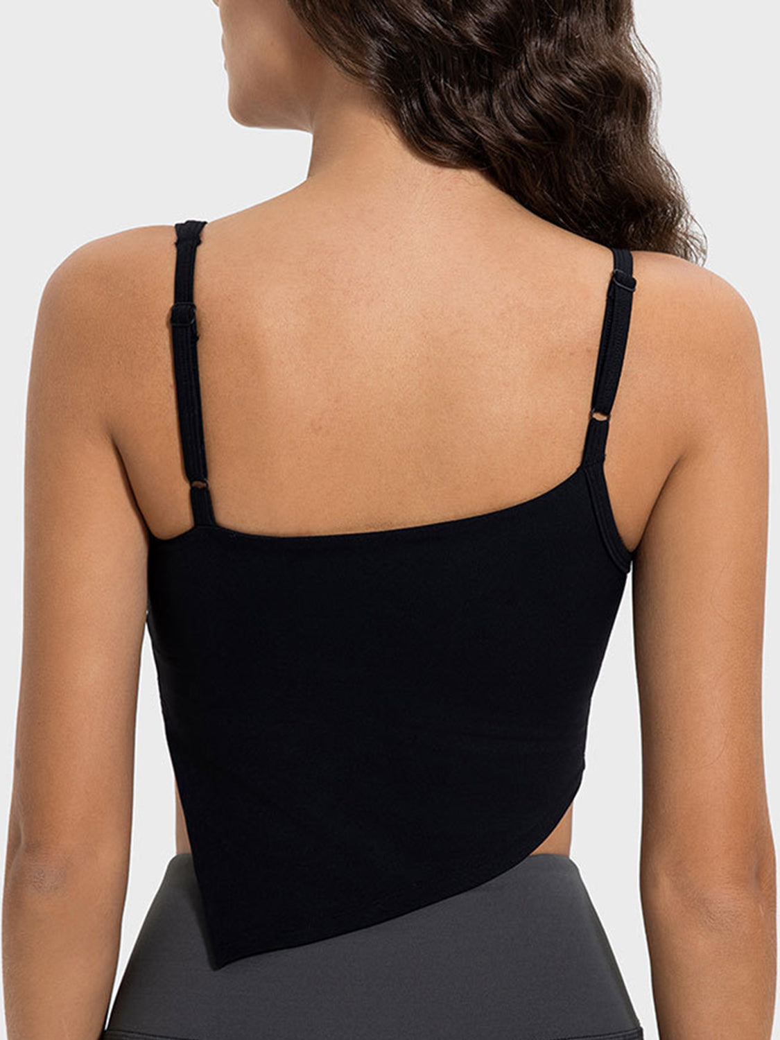 Black asymmetric cutout cami top with adjustable straps and a handkerchief hem