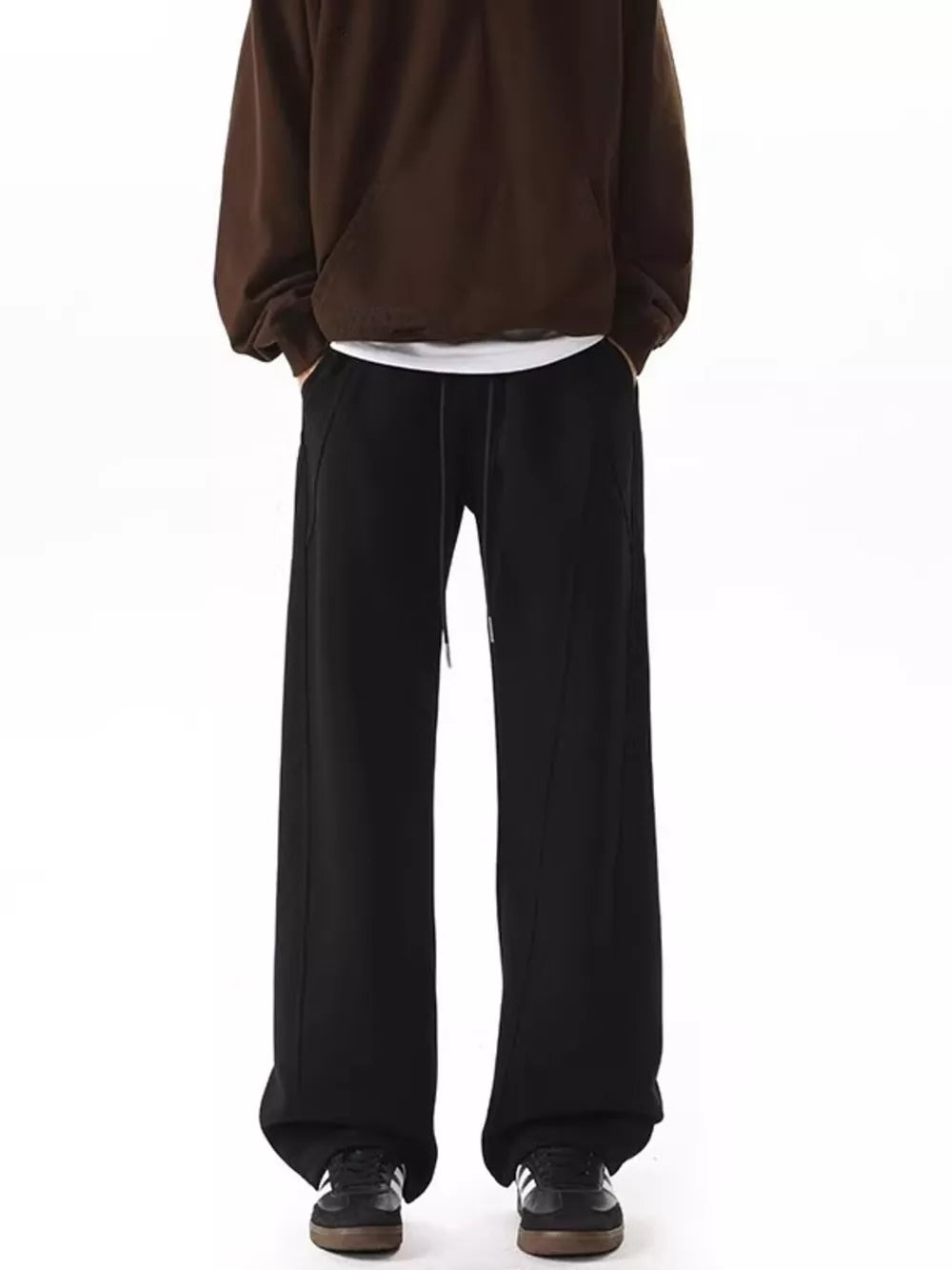 Men's black drawstring wide-leg pants with a relaxed fit and visible stitching detail.