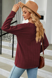 Burgundy textured cable-knit henley pullover with long sleeves.