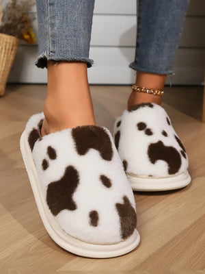 Cow print faux fur house slides in white and brown with a cream sole.