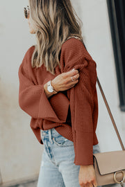 Textured knit sweater in ochre with bell sleeves and side slits.