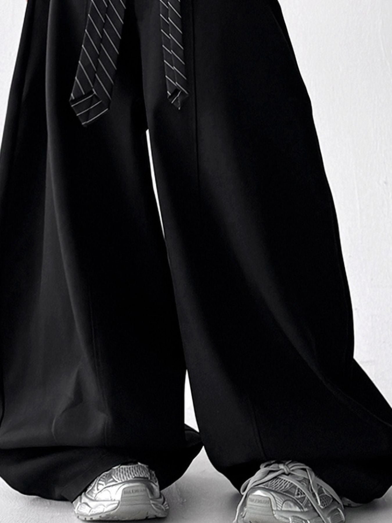 Men's black wide leg drawstring sweatpants with a striped tie detail.