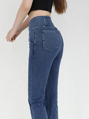 Medium wash denim jeans with crossover waist and flare leg, detailed view of back pockets.