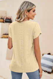 Light yellow knit top with allover eyelet detail and short sleeves.