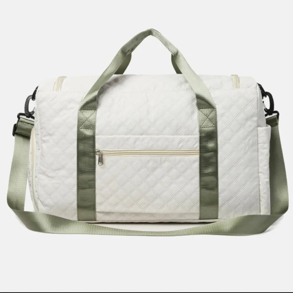 White quilted duffel bag with olive accents and a zippered front pocket.