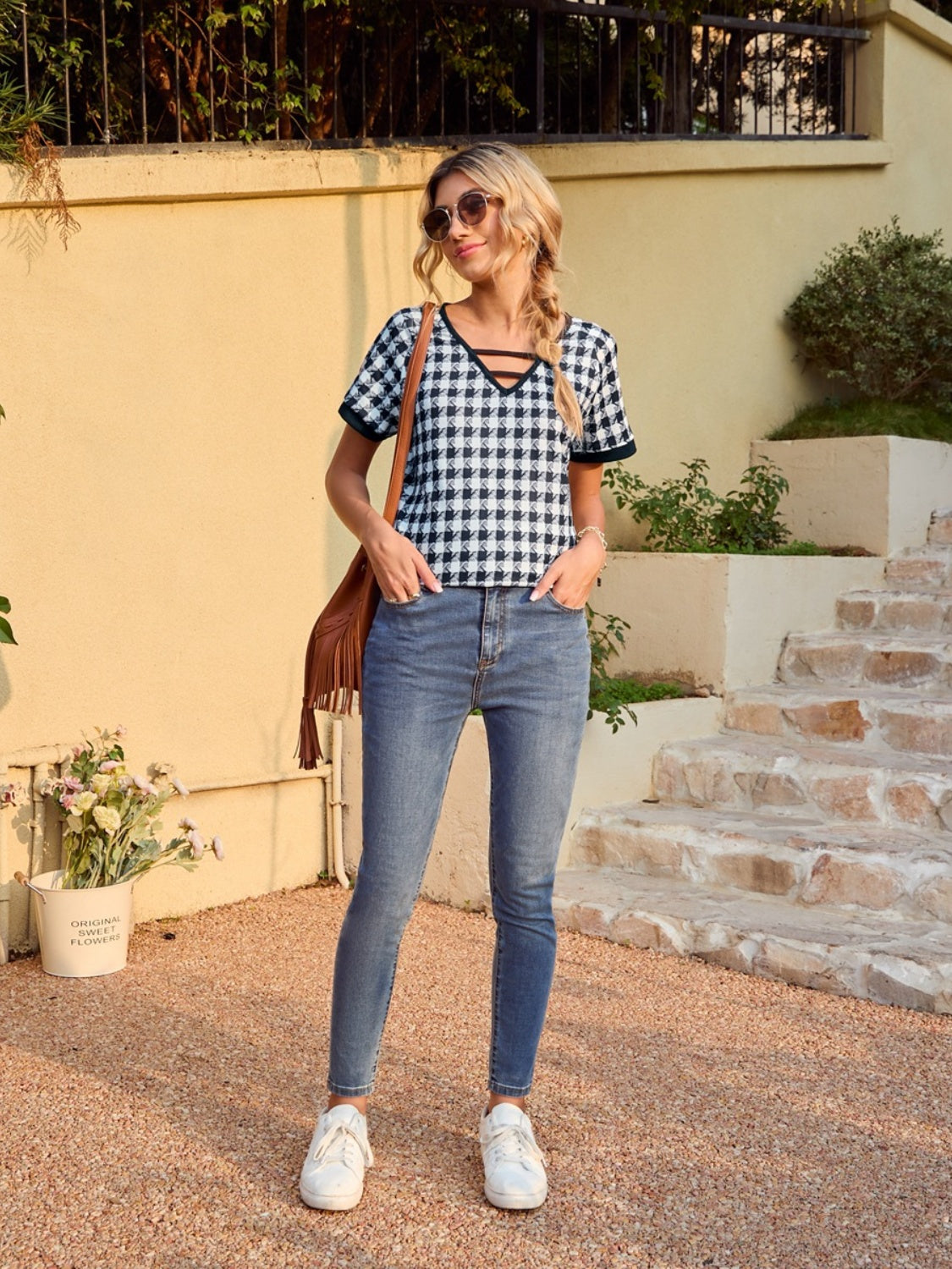 Houndstooth tunic top with cutout neckline and short sleeves, styled with jeans.