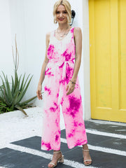 Women's hot pink tie-dye button-down jumpsuit with tie waist and wide legs.