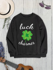 Black graphic sweatshirt with white "luck charmer" text and a green clover graphic.