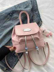 Pink leather mini drawstring backpack with beaded details and cute charm.