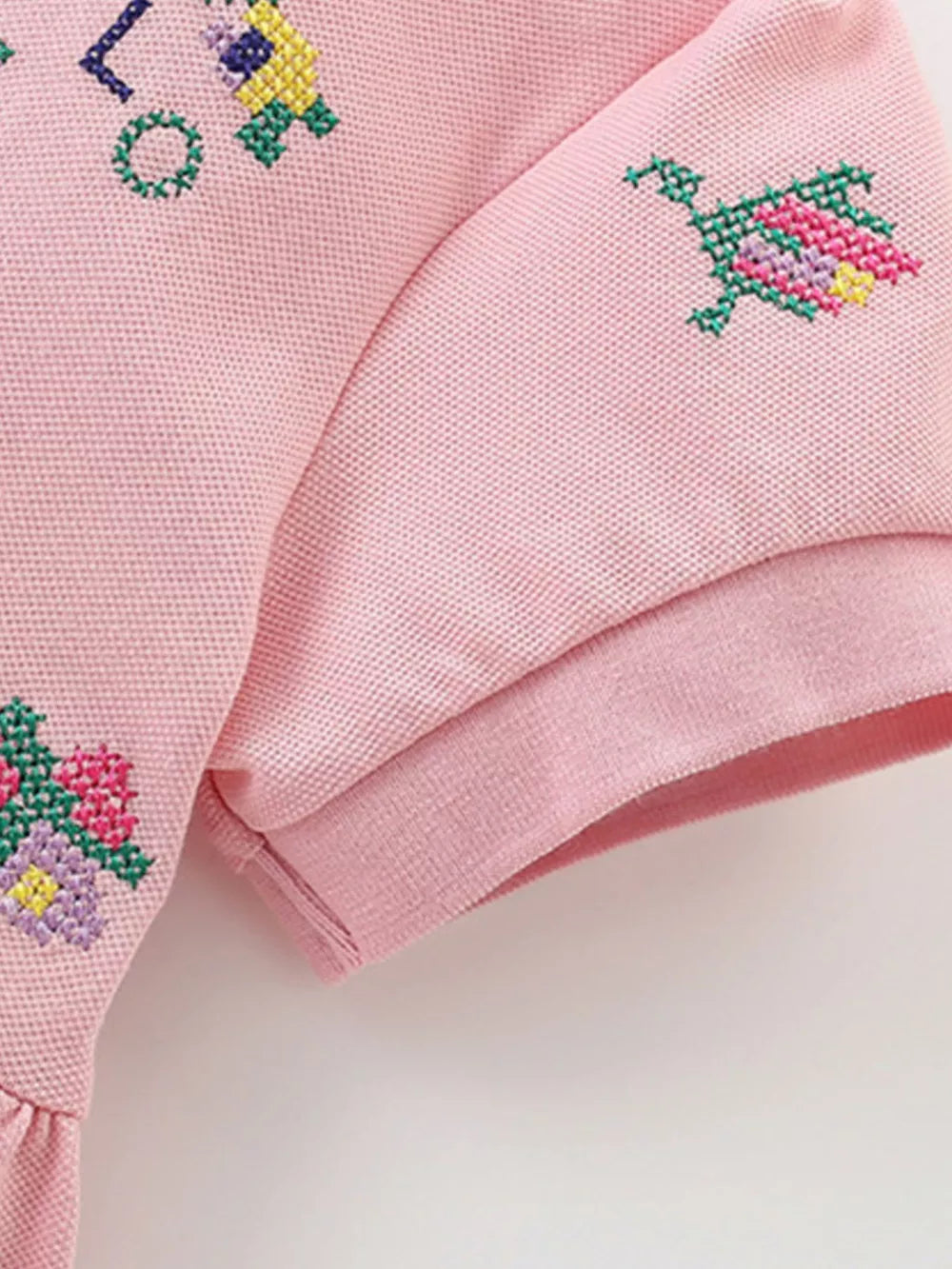 Pink cotton blend baby dress with embroidered flowers and a polo collar detail.
