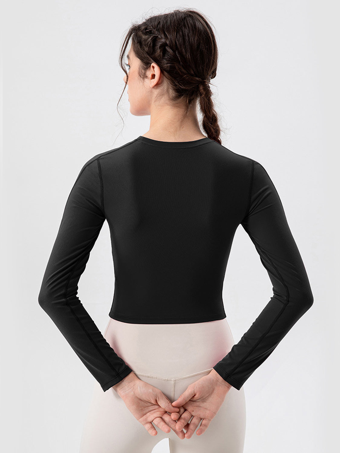 Black long sleeve crop top with mesh panels and crew neck.